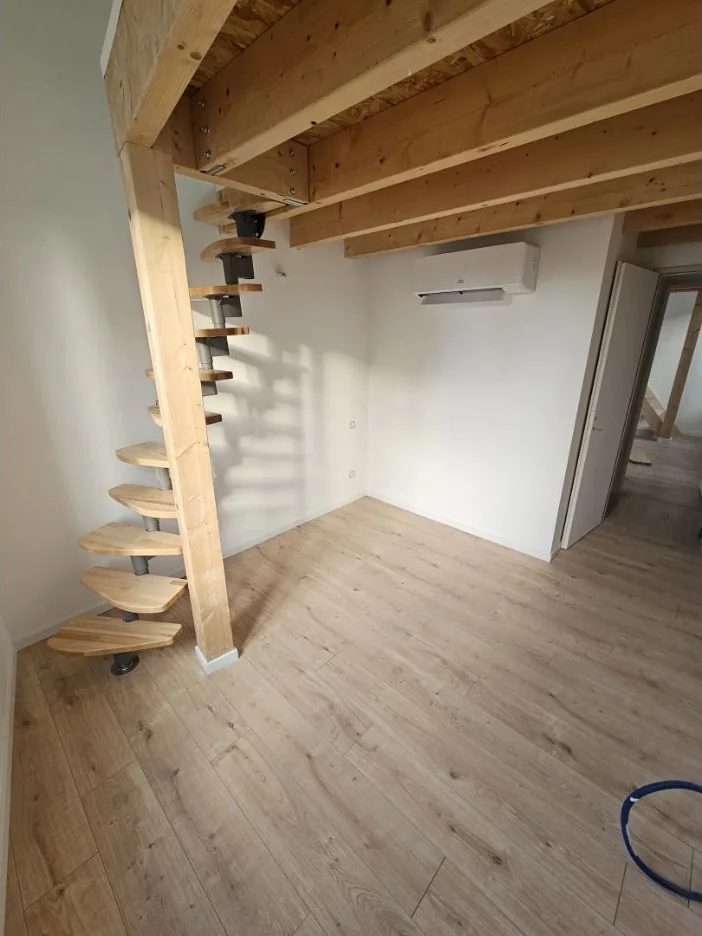 Escalier en bois donnant sur un intérieur clair