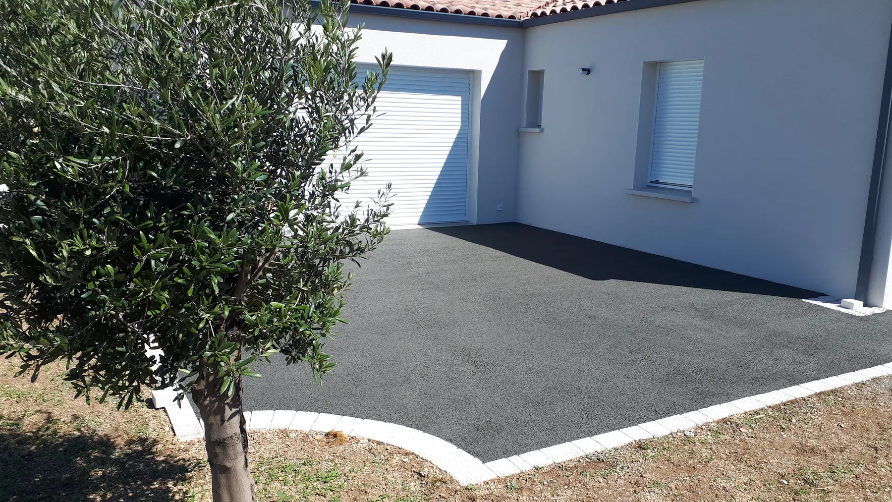 Cour aménagée devant une maison terminée